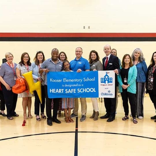 Group of people holding Heart Safe School sign